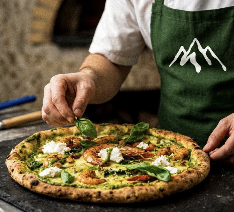 Le chef dresse une pizza au basilic sur le bar à pizza